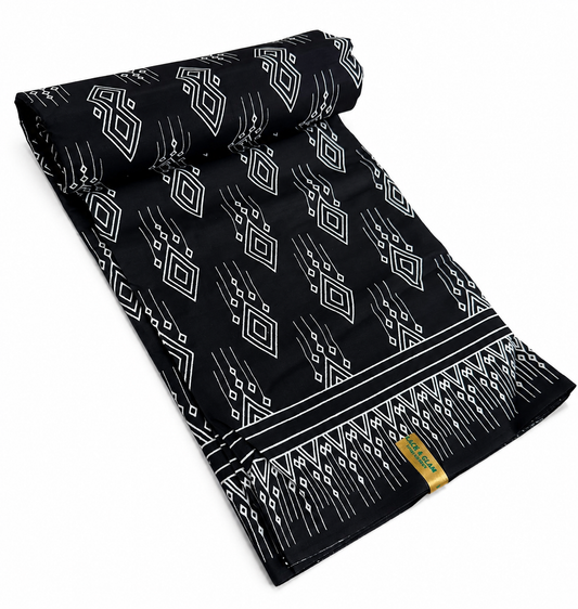Black and white geometric diamond African wax print cotton fabric rolled on white background showing full width and selvedge border