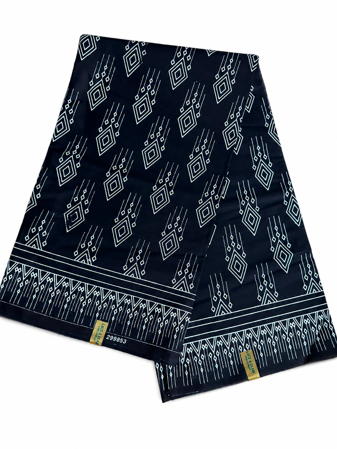 Couple wearing matching black and white geometric diamond African wax print outfits — woman in off-shoulder mermaid dress, man in printed trousers and white shirt