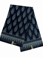 Couple wearing matching black and white geometric diamond African wax print outfits — woman in off-shoulder mermaid dress, man in printed trousers and white shirt