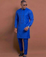 Man wearing royal blue African senator suit with double-breasted button bib placket, Mandarin collar and matching slim-leg trousers, three-quarter view