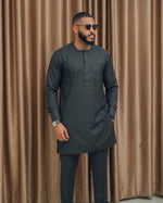 Man wearing charcoal grey minimalist African senator suit with round neck, short front placket, chest patch pocket and matching slim-leg trousers
