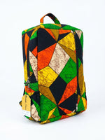 Side angle view of Ankara geometric patchwork backpack showing full kaleidoscope triangle print and padded backpack straps