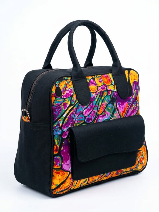 Side angle view of black Ankara bowling bag with vivid purple, orange and teal abstract fluid art print panel, padded top handles and front flap pocket