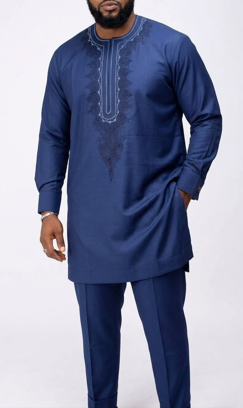 Man wearing navy blue African senator suit with white and navy embroidered bib panel, textured fabric and matching straight-leg trousers, front view