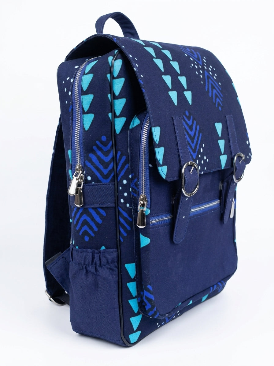 Side view of navy blue Ankara print satchel backpack with teal geometric triangle and chevron print, silver buckle straps and side zip pocket