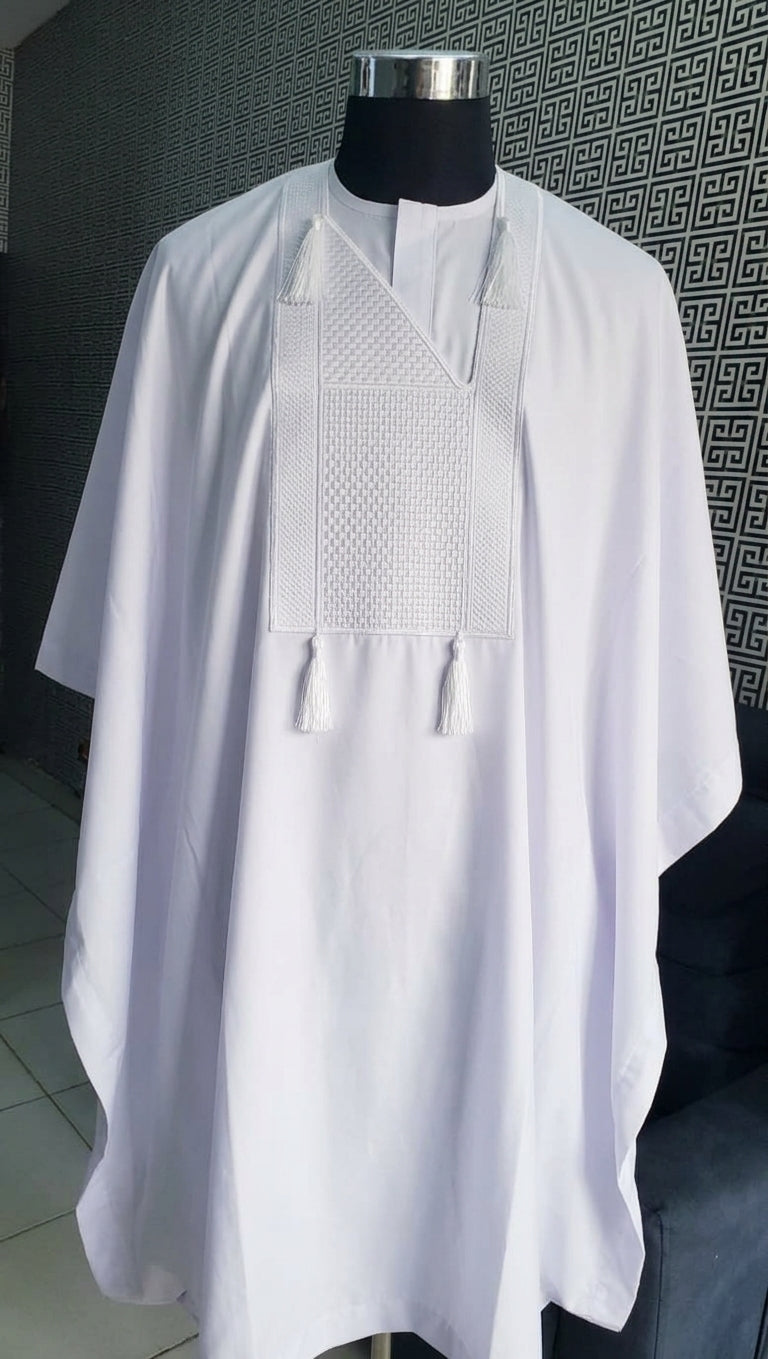 Men's white embroidered Nigerian Agbada Babariga on mannequin, featuring tonal geometric chest embroidery and white tassel ties