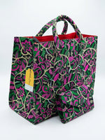 Ankara floral tote bag and clutch set in hot pink and green botanical print on black base, with Ankara-wrapped rope handles and red lining, House of Prints tag visible
