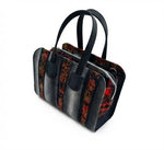 Three-quarter view of Ankara patchwork bowling bag showing full alternating polka dot and dark floral Ankara panel construction and structured silhouette