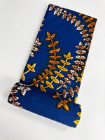 Family of five wearing matching royal blue and gold leaf vine Ankara outfits — mum, dad and three children coordinated