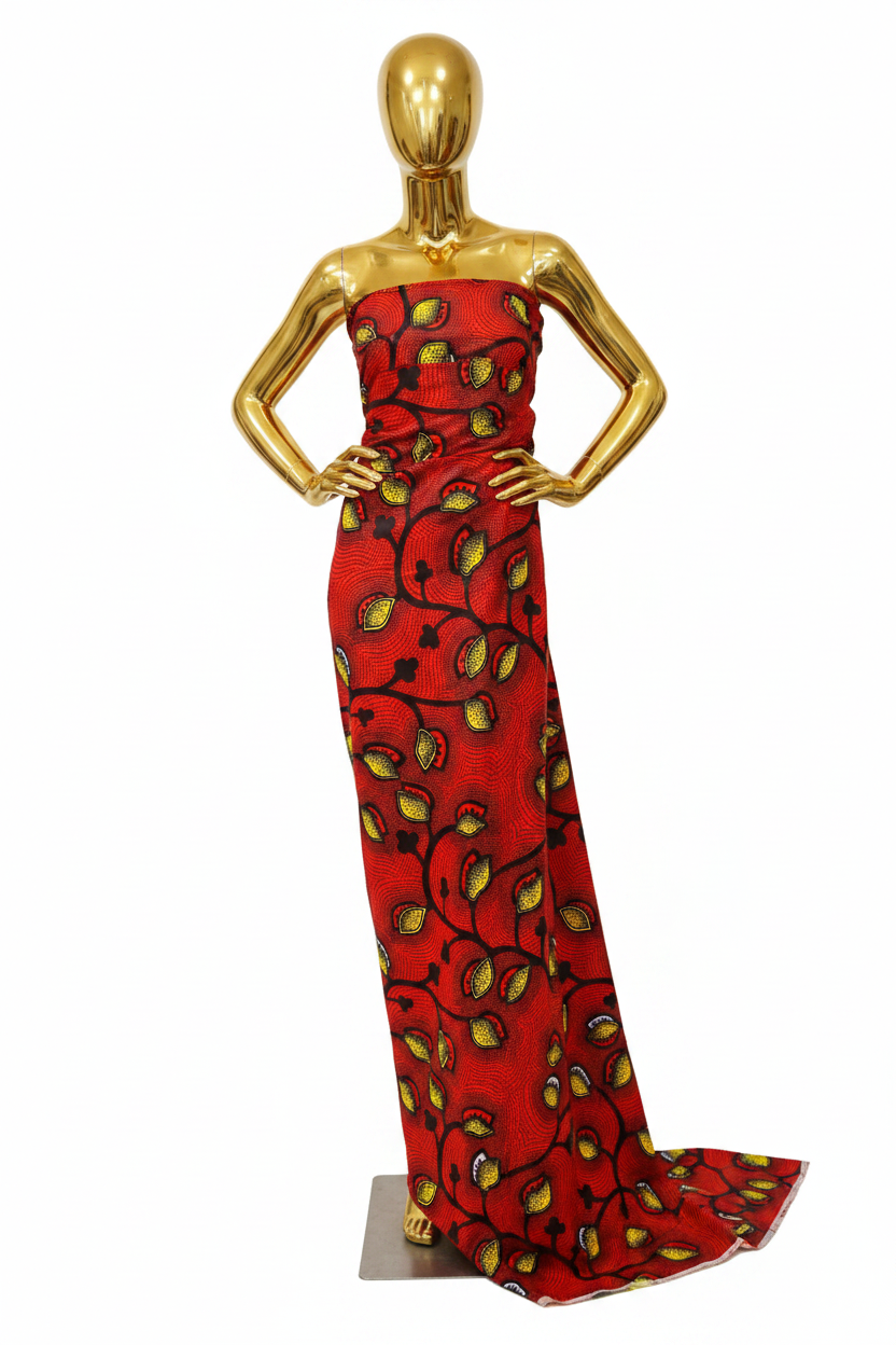 Red, yellow and black Ankara wax print fabric draped on a gold mannequin