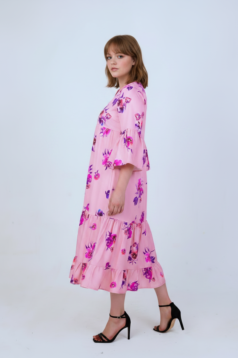 Pink floral satin tiered dress with bell sleeves, three-quarter turn pose