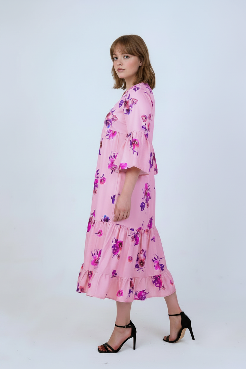 Pink floral satin tiered dress with bell sleeves, mixed race model, three-quarter turn pose