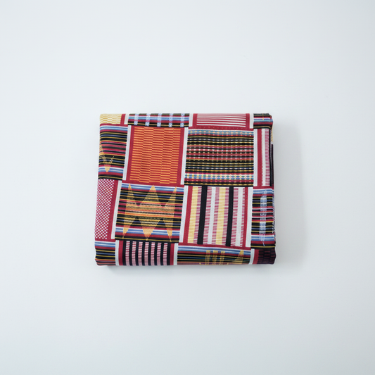 100% cotton Ankara Kente fabric flat lay — red geometric patchwork print, studio product shot on white background