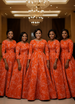 Five bridesmaids wearing matching orange abstract map print African wax cotton ball gowns at a formal event